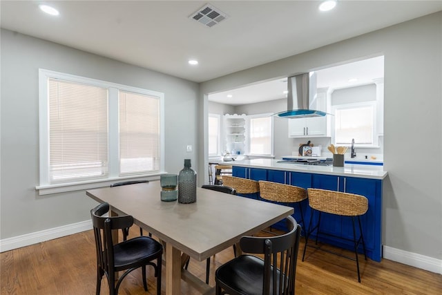 dining room with baseboards, visible vents, wood finished floors, and recessed lighting