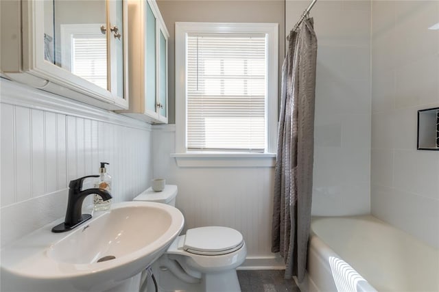 full bathroom with toilet, a wainscoted wall, plenty of natural light, and a sink