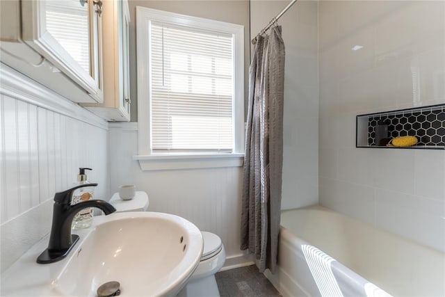 bathroom with shower / bath combo, a sink, and toilet