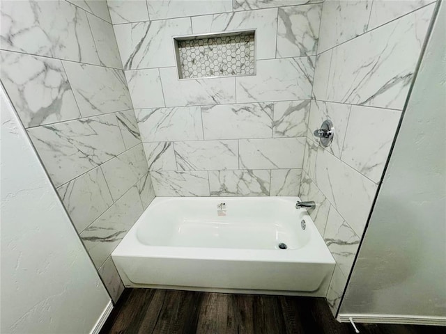 bathroom with tiled shower / bath and hardwood / wood-style floors