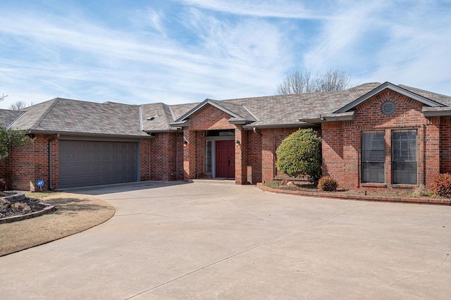 ranch-style house with brick siding, concrete driveway, and a garage