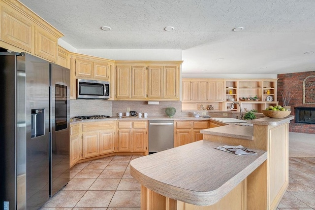 kitchen with a sink, light countertops, stainless steel appliances, and light brown cabinets