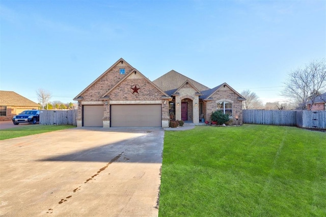 french country style house featuring driveway, brick siding, a front yard, and fence