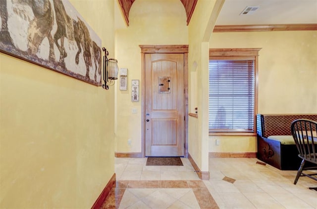 4220 Caribou St, Tuttle, OK 73089 - foyer entrance with tile patterned flooring, visible vents, arched walkways, crown molding, and baseboards