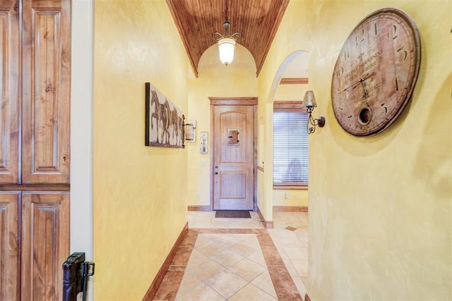 4220 Caribou St, Tuttle, OK 73089 - foyer entrance featuring light tile patterned flooring, arched walkways, baseboards, wooden ceiling, and lofted ceiling