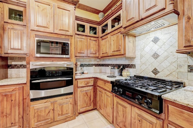4220 Caribou St, Tuttle, OK 73089 - kitchen with decorative backsplash, glass insert cabinets, light tile patterned floors, stainless steel appliances, and light stone countertops