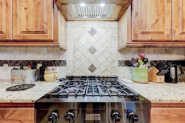 4220 Caribou St, Tuttle, OK 73089 - kitchen with light stone countertops, ventilation hood, backsplash, and stove