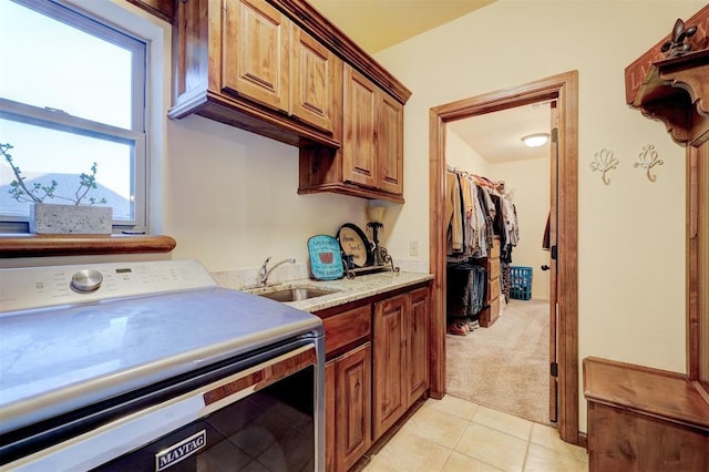 4220 Caribou St, Tuttle, OK 73089 - laundry room featuring a sink, light tile patterned flooring, light colored carpet, washer / clothes dryer, and cabinet space