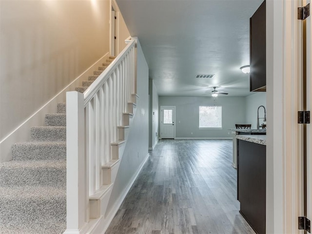 stairway featuring hardwood / wood-style flooring and ceiling fan