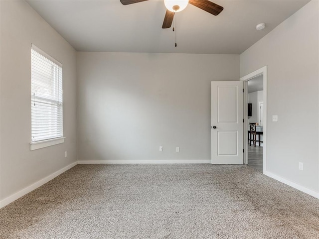 carpeted spare room featuring ceiling fan