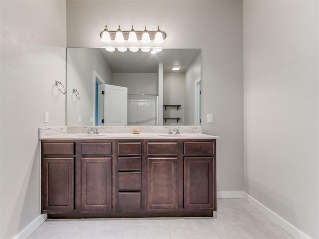 bathroom with tile patterned flooring, vanity, and walk in shower