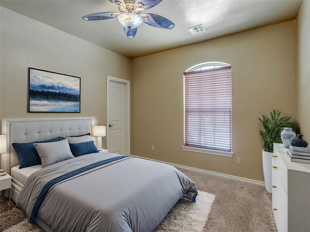 bedroom with baseboards, visible vents, a ceiling fan, and light colored carpet