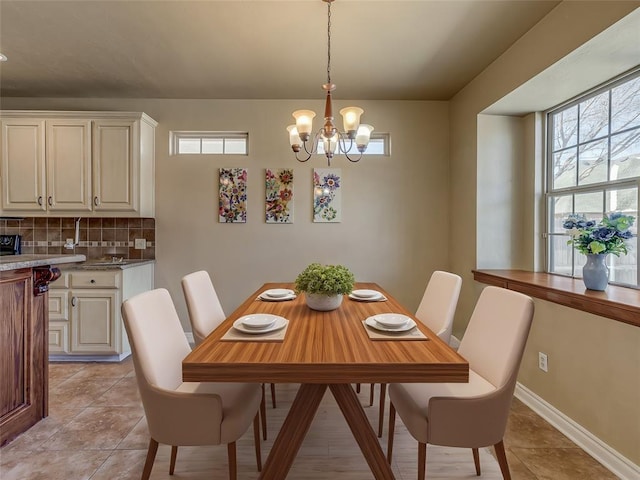 dining room with baseboards and a notable chandelier