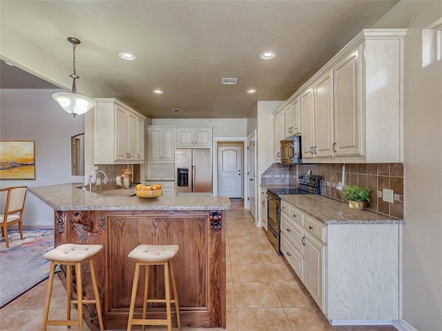 kitchen with a breakfast bar area, a peninsula, light stone countertops, black appliances, and decorative light fixtures