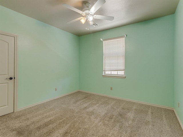 empty room featuring carpet floors, baseboards, visible vents, and a ceiling fan