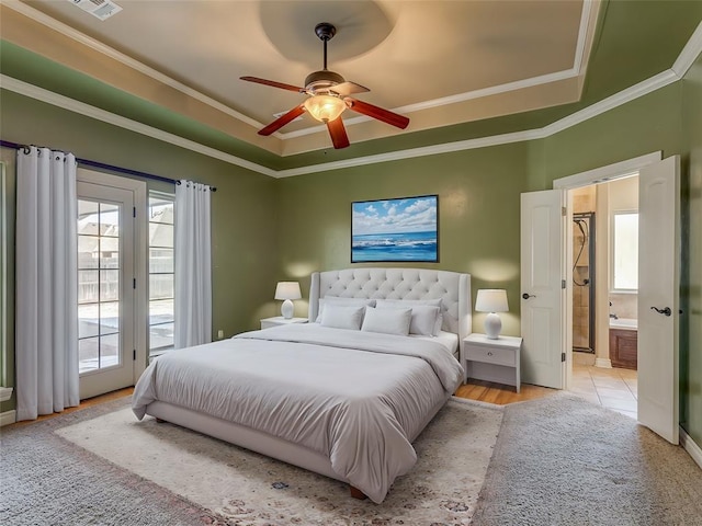 bedroom with access to outside, a raised ceiling, crown molding, and ensuite bathroom