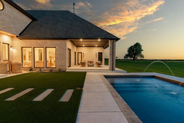 20945 Alba Ct, Edmond, OK 73012 - rear view of house with a lawn, a patio area, an outdoor pool, and brick siding