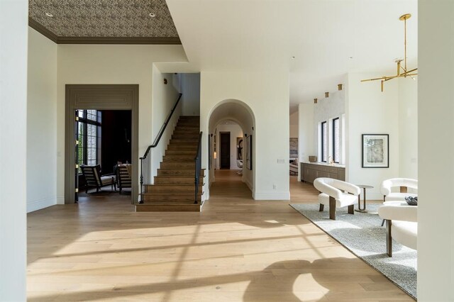 20945 Alba Ct, Edmond, OK 73012 - foyer entrance with wood finished floors, stairs, a chandelier, baseboards, and a towering ceiling