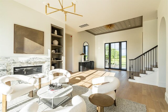 20945 Alba Ct, Edmond, OK 73012 - living room with built in shelves, a chandelier, wood-type flooring, stairway, and baseboards
