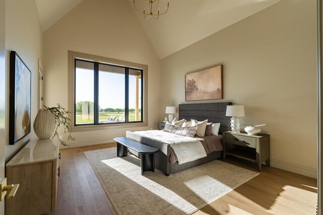 20945 Alba Ct, Edmond, OK 73012 - bedroom with wood finished floors, baseboards, high vaulted ceiling, and a chandelier