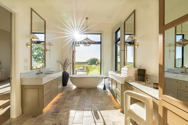 20945 Alba Ct, Edmond, OK 73012 - bathroom with stone tile floors, a freestanding bath, and two vanities