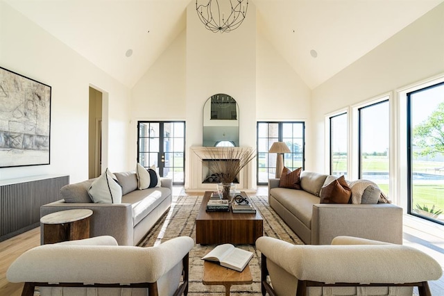 20945 Alba Ct, Edmond, OK 73012 - living room with high vaulted ceiling, plenty of natural light, light wood-style floors, and a chandelier