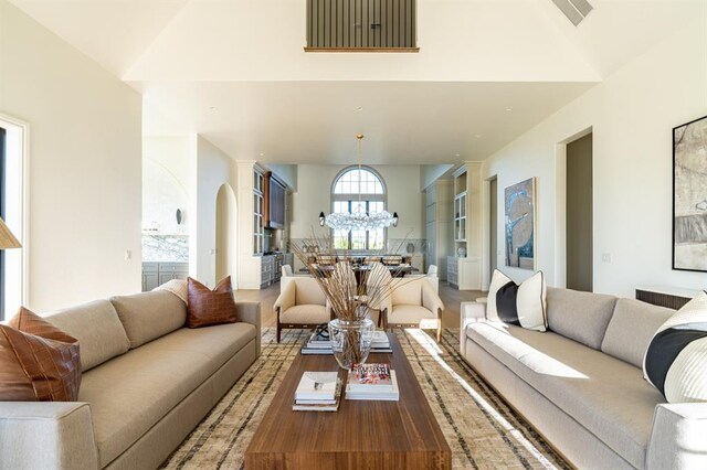 20945 Alba Ct, Edmond, OK 73012 - living area featuring a chandelier, wood finished floors, and vaulted ceiling