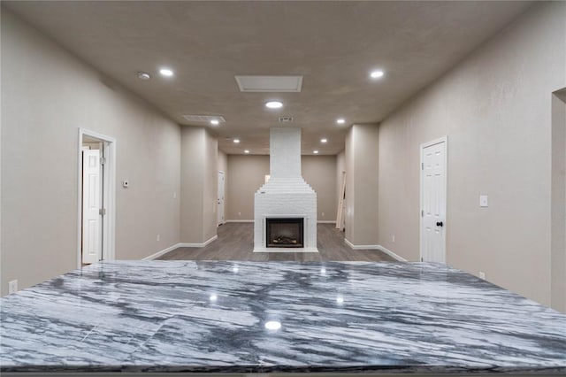 interior space with hardwood / wood-style floors and a large fireplace