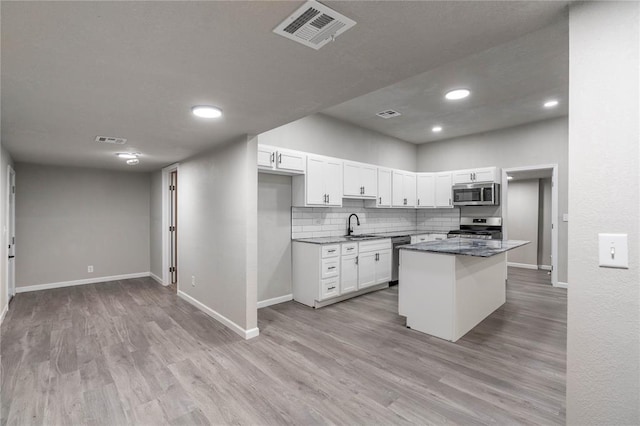 kitchen featuring sink, stainless steel appliances, white cabinets, and light hardwood / wood-style floors