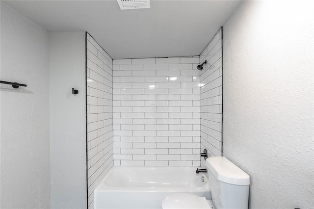 bathroom with toilet and tiled shower / bath combo