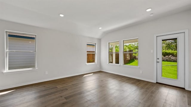 spare room with dark hardwood / wood-style flooring and lofted ceiling