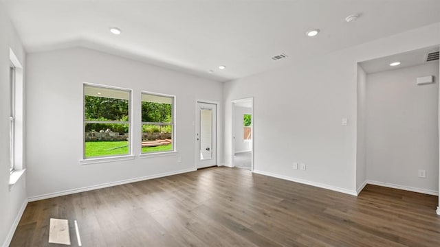 spare room with vaulted ceiling and dark hardwood / wood-style floors