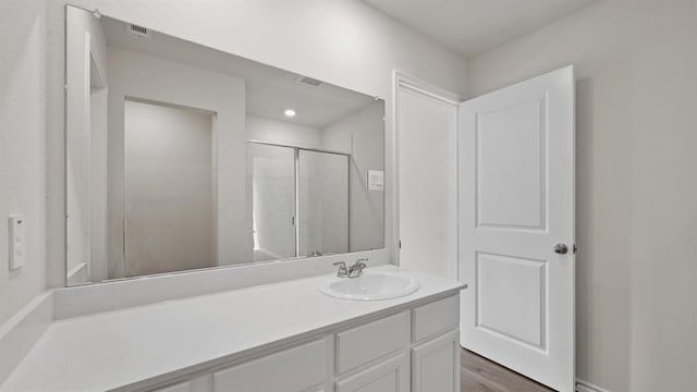 bathroom featuring vanity and a shower with shower door