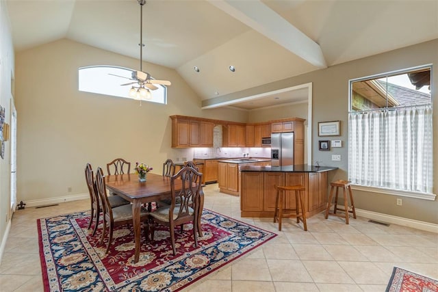 dining area with a ceiling fan, a wealth of natural light, baseboards, and light tile patterned floors