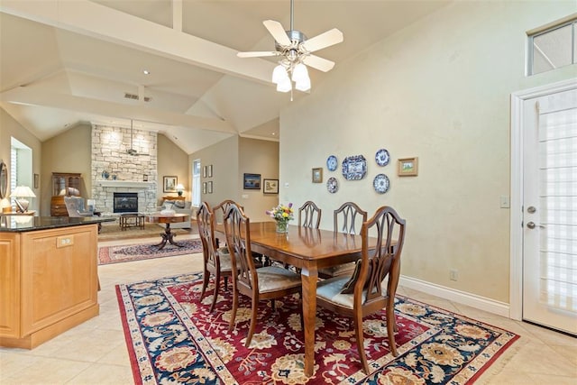 dining area with ceiling fan, light tile patterned flooring, a fireplace, and beam ceiling