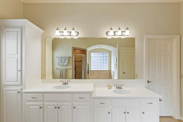 full bath featuring a sink, a shower stall, and double vanity