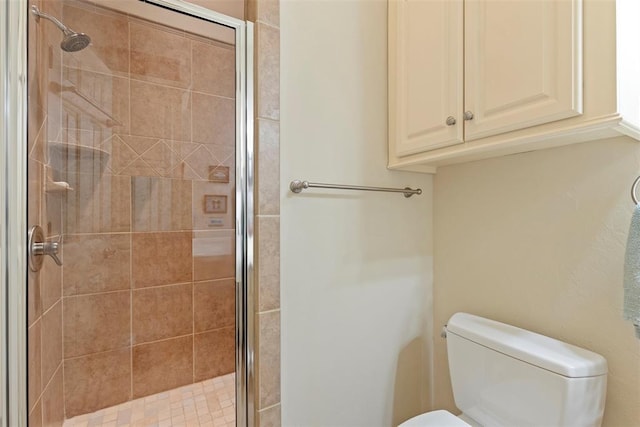 full bathroom featuring a stall shower and toilet