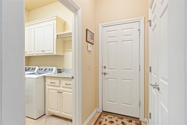 clothes washing area with cabinet space, independent washer and dryer, baseboards, and light tile patterned flooring