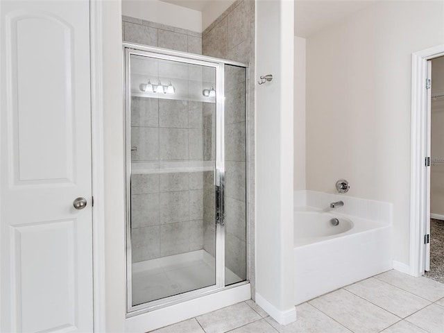 full bath featuring baseboards, a bath, a shower stall, and tile patterned flooring