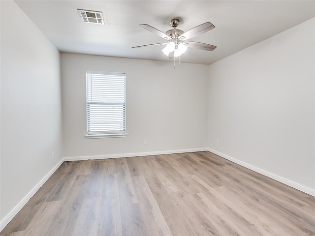 empty room with visible vents, baseboards, and wood finished floors