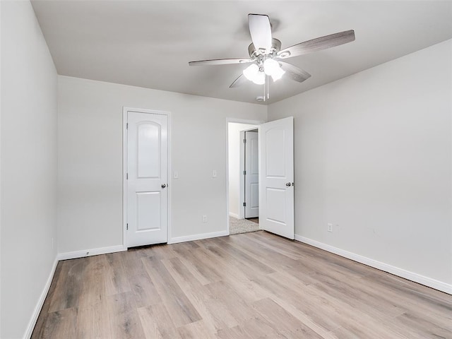 empty room with baseboards, light wood-style flooring, and a ceiling fan