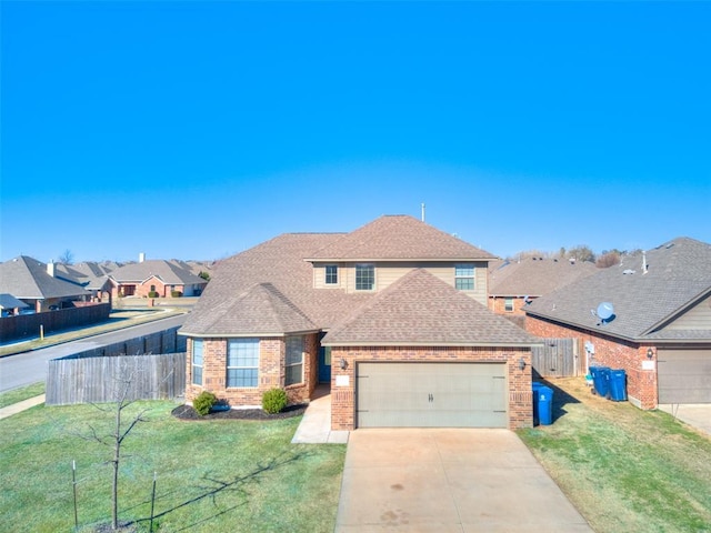 traditional home with brick siding, fence, concrete driveway, a front yard, and an attached garage