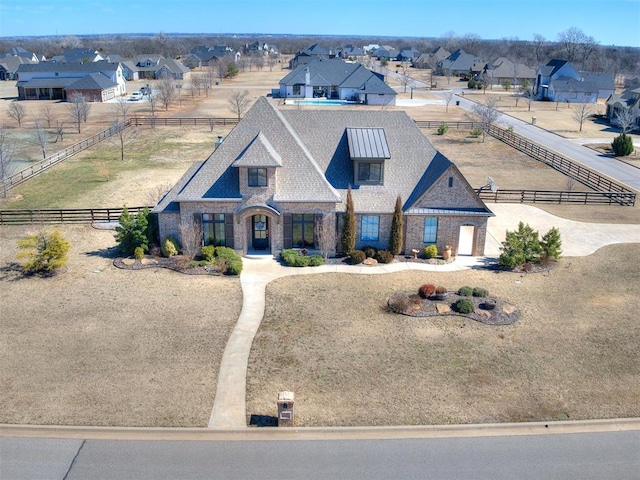 view of front of house featuring a residential view, fence, and brick siding