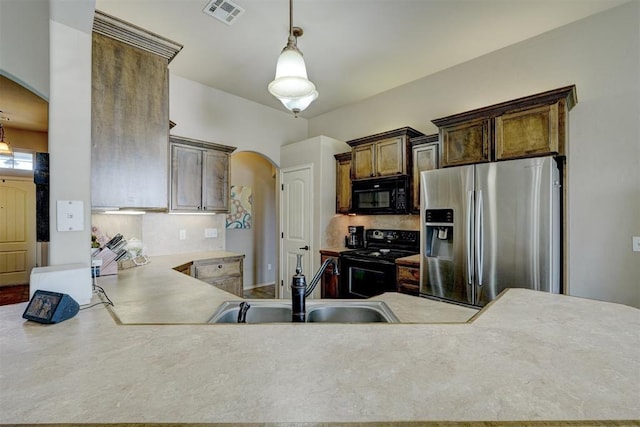 kitchen featuring sink, backsplash, black appliances, kitchen peninsula, and hanging light fixtures