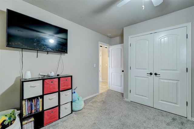 carpeted bedroom featuring ceiling fan and a closet