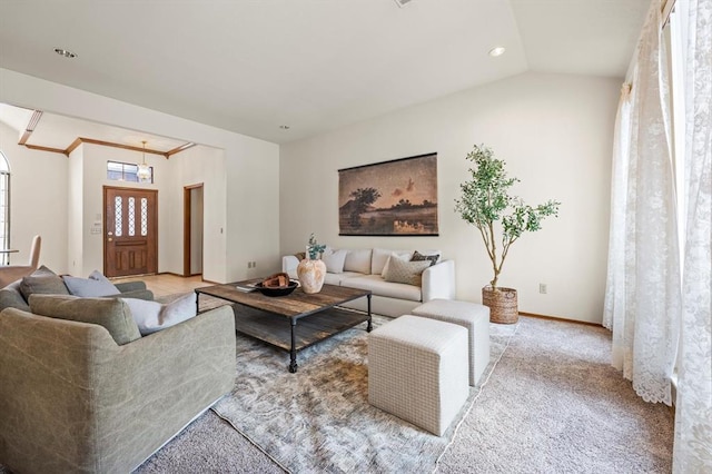 living area with lofted ceiling, baseboards, and light colored carpet