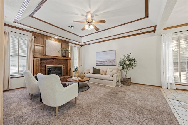 living area featuring light tile patterned flooring, a fireplace, a raised ceiling, and visible vents