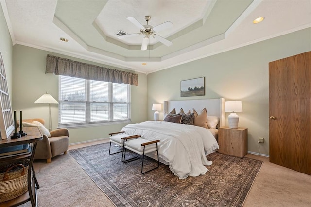 bedroom featuring carpet floors, visible vents, baseboards, ornamental molding, and a raised ceiling