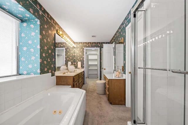 full bath featuring wallpapered walls, a whirlpool tub, a walk in closet, vanity, and a shower stall