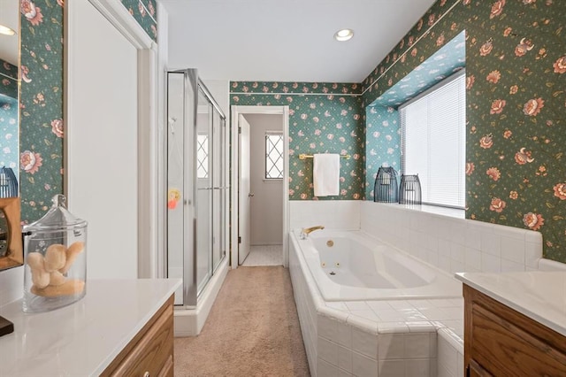 bathroom with wallpapered walls, a tub with jets, a stall shower, and vanity